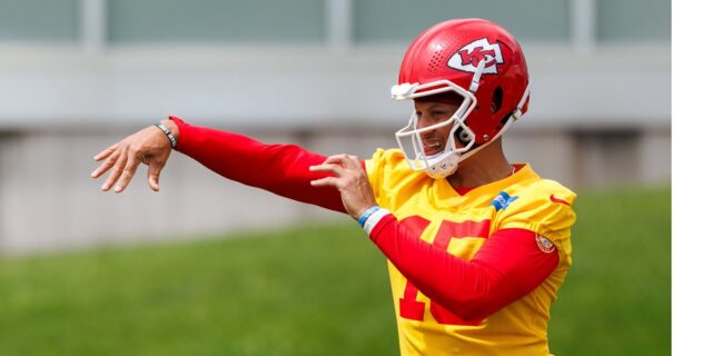 Patrick Mahomes throws during Kansas City Chiefs OTAs on May 26, 2026 with a brace on his left knee while rehabbing a torn ACL.